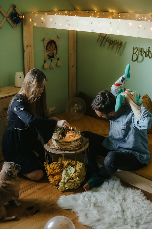a man and woman blowing out candles on a cake