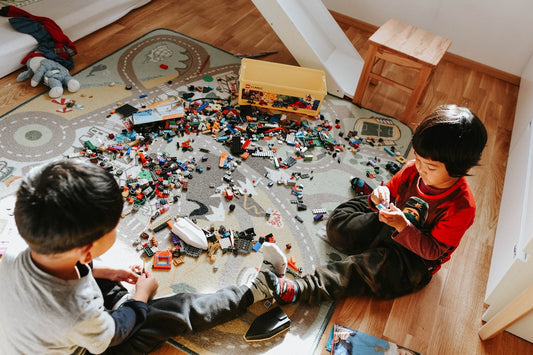 two young boys playing with legos on the floor