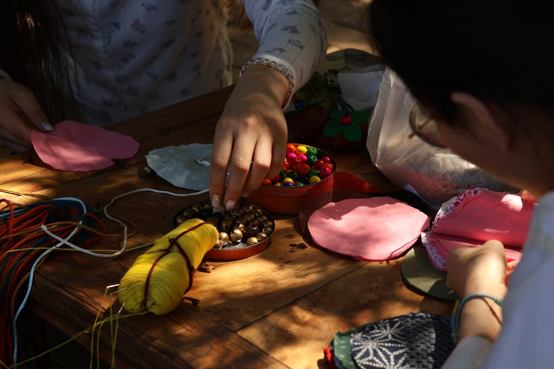 Hands crafting colorful objects on a wooden table.
